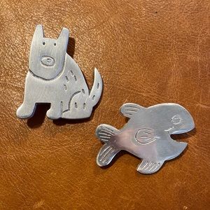 Silver metal dog and fish pins.